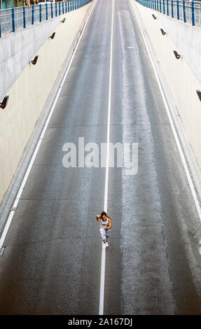 Vista superiore del giovane sportivo donna in esecuzione su una strada Foto Stock