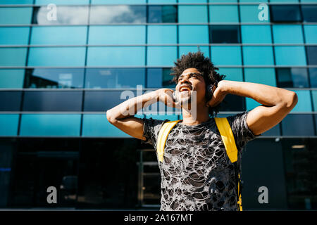 Cantando l uomo con cuffie cordless all'aperto, Barcellona, Spagna Foto Stock