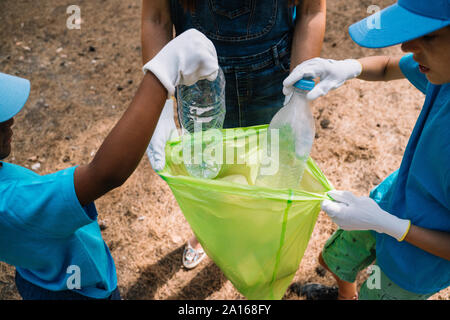 Close-up di volontariato bambini raccogliere rifiuti in un parco Foto Stock