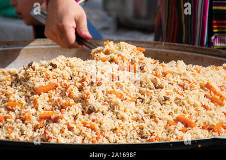 Reale strada tradizionale pilaf o plov, piatto di riso per la cottura in brodo o brodo, l'aggiunta di spezie e altri ingredienti come la verdura o la carne Foto Stock