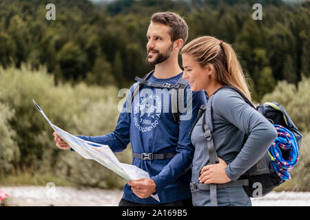 Una giovane coppia in un viaggio escursionistico mappa di lettura, Vorderriss, Baviera, Germania Foto Stock