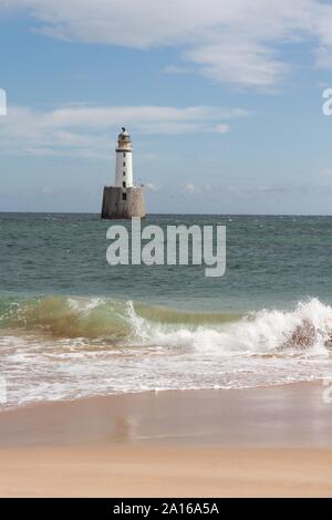 Faro bianco sulla piattaforma in mare Foto Stock