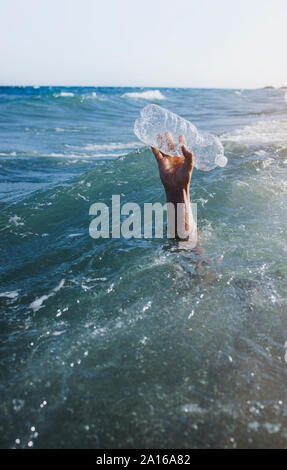 Mano d'uomo di prelevare la bottiglia di plastica Foto Stock