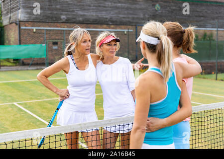 Donne mature parlando di erba corte al tennis club Foto Stock