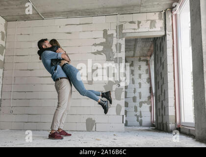 Coppia felice di futuri proprietari al sito in costruzione Foto Stock