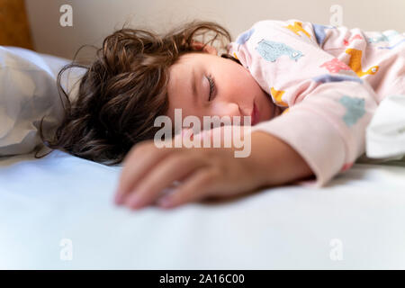 Carino piccola ragazza dorme nel letto Foto Stock