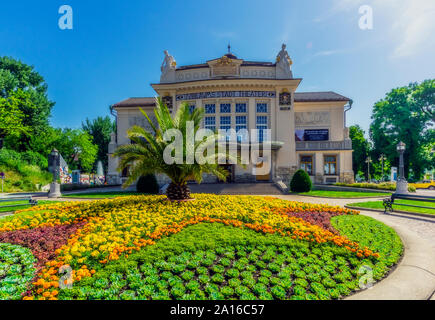 Austria, Carinzia, Klagenfurt, Stadttheater Klagenfurt con aiuola di fiori in primo piano Foto Stock