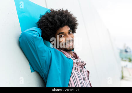 Ritratto di giovane uomo appoggiato sulla parete bianca Foto Stock