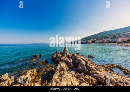 Fanciulla con il gabbiano alla costa del Mare Adriatico contro il cielo blu Foto Stock
