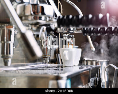 Due tazzine getting riempito in una macchina portafilter Foto Stock