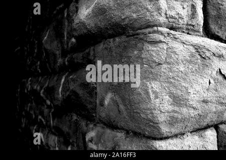 In prossimità di un angolo di un vecchio muro di pietra in bianco e nero Foto Stock