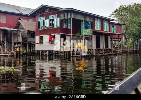 Un locale Uomo al lavoro su una casa in villaggio Nampan, Lago Inle, Stato Shan, Myanmar. Foto Stock