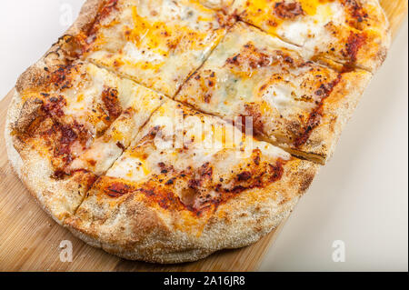 Closeup Pizza quattro formaggi su un tagliere Foto Stock