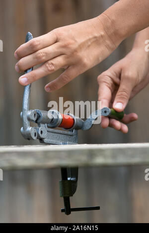 Le mani della cartuccia di ricarica dal guscio shotgun reloader, primo piano Foto Stock