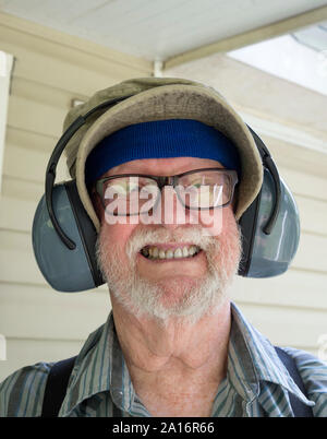 Uomo anziano pronto a falciare con la sua cuffie a. Foto Stock