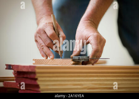 Le mani di un maschio di builder la misurazione di una porta e contrassegnarla con una matita. Foto Stock