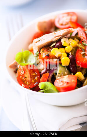 Insalata mista con tonno bianco e kindey fagioli, pepe rosso, il mais dolce, rosso cipolla, prezzemolo e basilico. Foto Stock