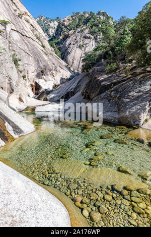 La cascata e piscina naturale nel famoso Purcaraccia Canyon in Bavella durante l'estate. La cascata forme diapositiva naturali nelle rocce. La Corsica, Francia Foto Stock