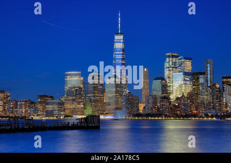 Vista notturna di One World Trade Center e lo skyline di Manhattan con il fiume Hudson in primo piano.New York City.USA Foto Stock