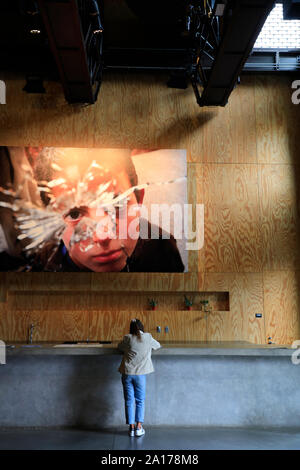 Un visitatore di fronte ad una fotografia di un ragazzo dietro un vetro rotto. Photoville annuale mostra fotografica nel ponte di Brooklyn Park.New York City.USA Foto Stock