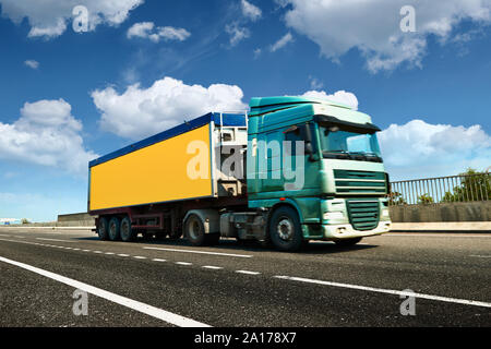 Carrello giallo è su autostrada - business, commerciali, trasporto merci concetto, chiaro e uno spazio vuoto sulla vista laterale Foto Stock