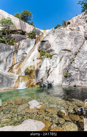 La cascata e piscina naturale nel famoso Purcaraccia Canyon in Bavella durante l'estate, una destinazione turistica e di attrazione (per canyoning e trekking). Foto Stock