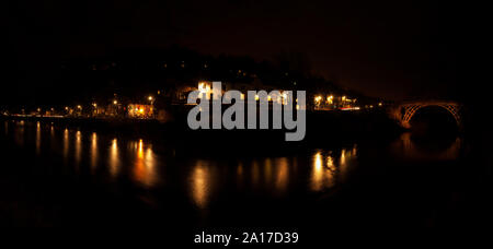 Panaroma di banchina a città di Ironbridge, Shropshire sul fiume Severn durante la notte con le luci di strada che riflette nell'acqua. Foto Stock
