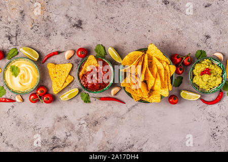 Cibo messicano background: guacamole, salsa di formaggio salse con nachos, vista dall'alto. Foto Stock