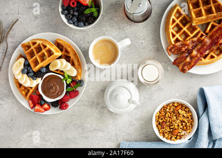 Tavolo per la colazione con cialde, frutti di bosco freschi, caffè e granola