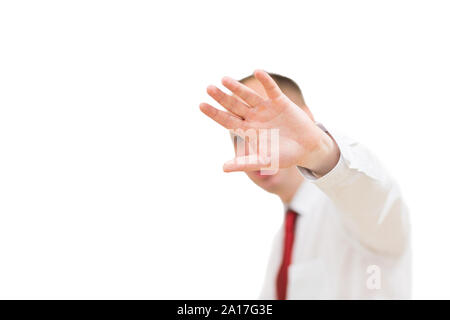 Scioccato e terrorizzato uomo vieta di scattare le foto di se stesso. Ritratto di giovane uomo in camicia e cravatta rossa che copre il volto con la mano e guardando è venuto Foto Stock