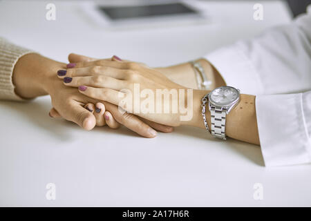 Donna medico paziente calma e trattiene la mano. Foto Stock