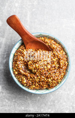 Grano intero senape nella ciotola sul tavolo da cucina. Vista dall'alto. Foto Stock