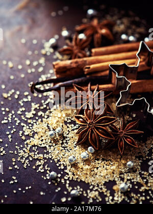 Biscotti di Natale, spezie, frutta e zucchero di canna sul rustico sfondo di legno Foto Stock