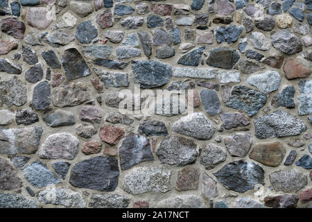 Il vecchio muro di pietra con un sacco di consistenza e di colore. Foto Stock