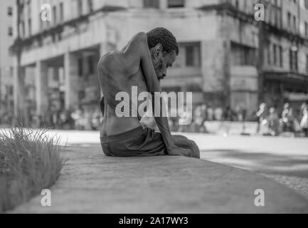 Uomo con malattia congenita seduto in un Recife downtown garden Foto Stock