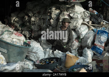 Riciclatore uomo nelle strade di Klong Toey tra i rifiuti Foto Stock