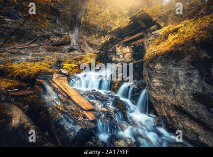 Stony ben in colorate arancio foresta con piccola cascata Foto Stock