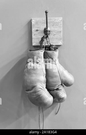 Retrò i guantoni. vintage attrezzature sportive. concetto di inscatolamento. vecchio i guantoni sulla bilancella. storia dello sport. Indossate guanti. stamina. pugilato Fight Club. Sport di successo. Guanti Vintage appendere sul gancio. Foto Stock