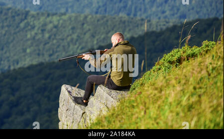 Stile militare. maschio nel camuffamento. muscolare di man tenere arma. Scopo e successo. forze armate. sniper raggiungere la montagna bersaglio. soldato nel campo. poligono. l uomo pronto a far fuoco. hunter hobby. Foto Stock