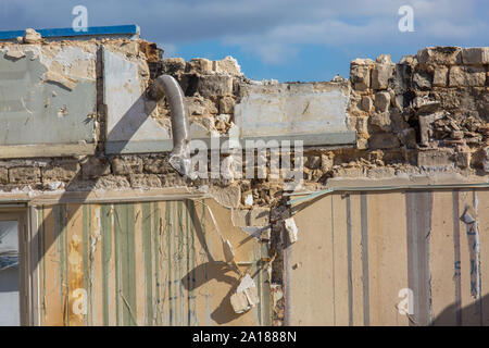 Vecchio edificio di essere demolito. close up su una parete ripiegata Foto Stock