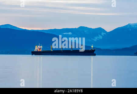 Contenitore di carico Velebit nave ormeggiata in porto esterno di Burrard ingresso nel porto di Vancouver con montagne litoranee sfondo Foto Stock