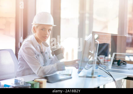 Designer femmina in ufficio a lavorare su progetto degli architetti Foto Stock
