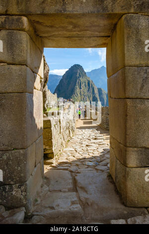 Machu Picchu sunrise, la Valle Sacra degli Incas, Perù. Turisti e porta principale portale della città perduta, Huayna Picchu, Machu Pichu, la mattina presto. Foto Stock