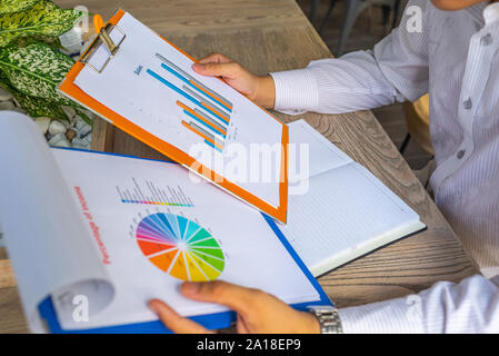 Dirigente finanziario holding grafico a colonne colorate e grafico a torta documento Foto Stock