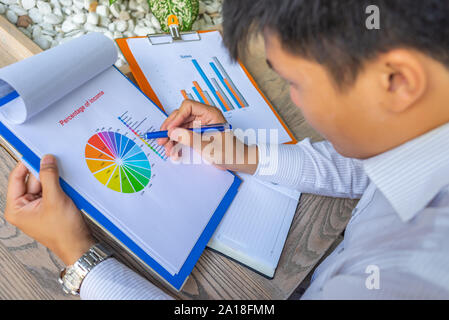 Asian dirigente finanziario analizzando i dati nel grafico a torta documento Foto Stock