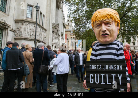Londra, Regno Unito. 24Sep, 2019. Un manifestante indossando un prigioniero il vestito e del Primo Ministro britannico Boris Johnson la maschera per il viso al di fuori della Corte suprema il giorno in cui la Corte ha dichiarato che il Primo Ministro britannico Boris Johnson per la decisione di prorogue il Parlamento è illegale. Credito: SOPA Immagini limitata/Alamy Live News Foto Stock