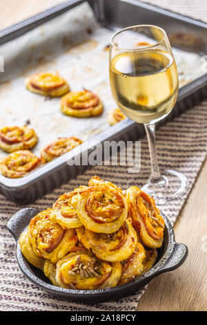 Rotoli di pasta sfoglia con prosciutto formaggio pancetta sesamo nel piatto Foto Stock