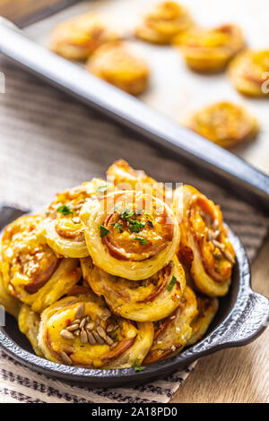 Rotoli di pasta sfoglia con prosciutto formaggio pancetta sesamo nel piatto Foto Stock