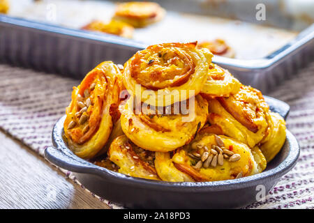 Rotoli di pasta sfoglia con prosciutto formaggio pancetta sesamo nel piatto Foto Stock