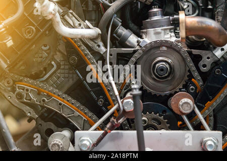 Close-up su un motore smontato con una vista del sistema di distribuzione di gas meccanismo, catena, gli ingranaggi e i tenditori durante gli interventi di riparazione e restauro dopo una bre Foto Stock